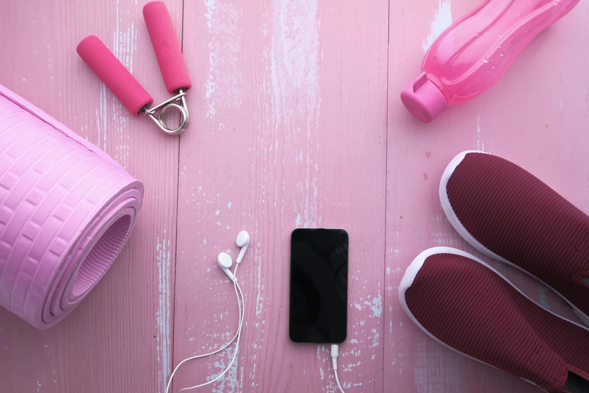 Top view of fitness accessories including yoga mat, shoes, water bottle, and smartphone on pink w... (Photo by Towfiqu barbhuiya on Pexels)