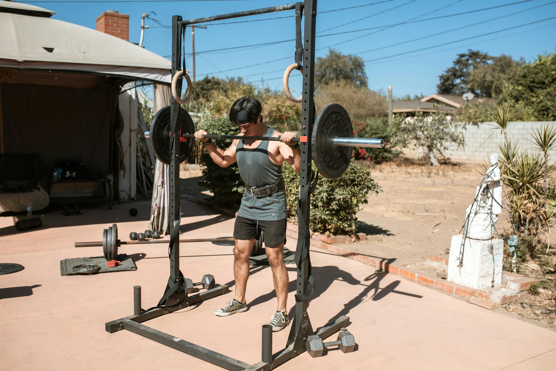 Man doing a barbell squat in an outdoor gym setting for strength training. (Photo by RDNE Stock project on Pexels)