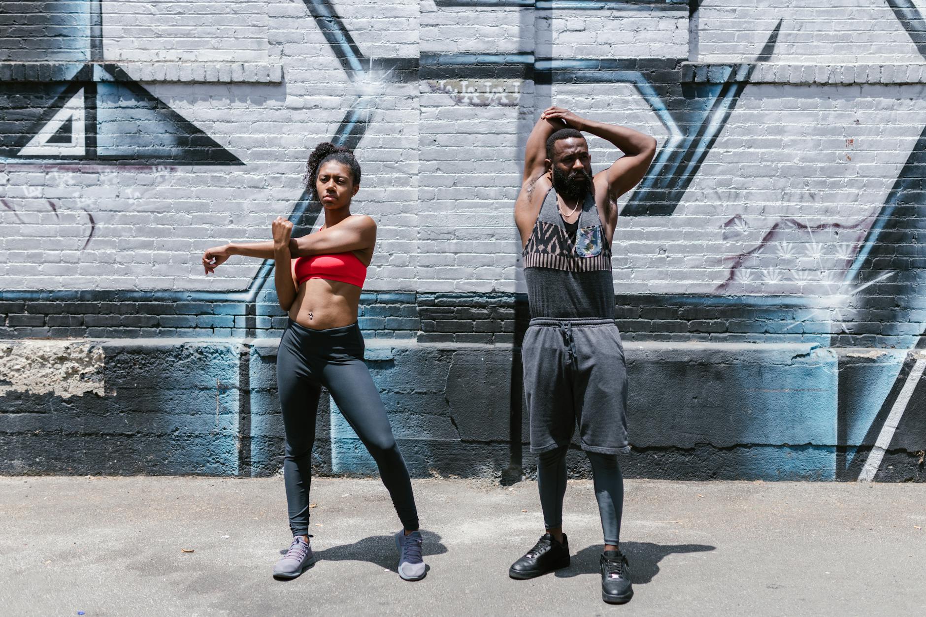 Two people engaging in a dynamic street workout session, showcasing fitness and healthy lifestyle. (Photo by RDNE Stock project on Pexels)